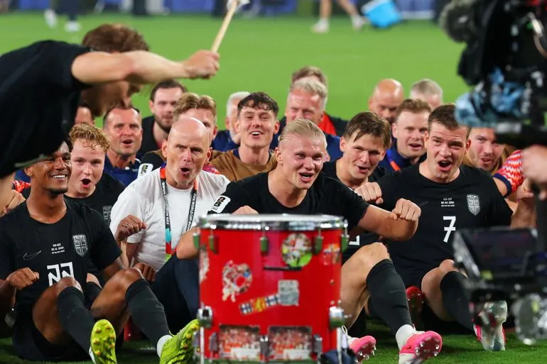 Norway's players and coaching staff perform a rowing-style celebration together on the pitch